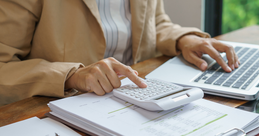 Consultant calculant son salaire en portage salarial avec une calculatrice et documents financiers